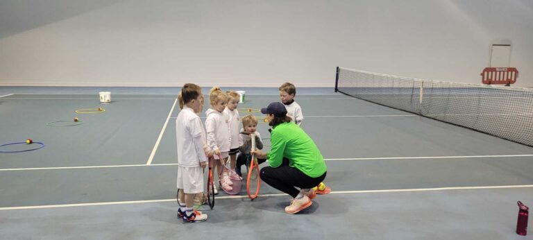woman coaching children tennis